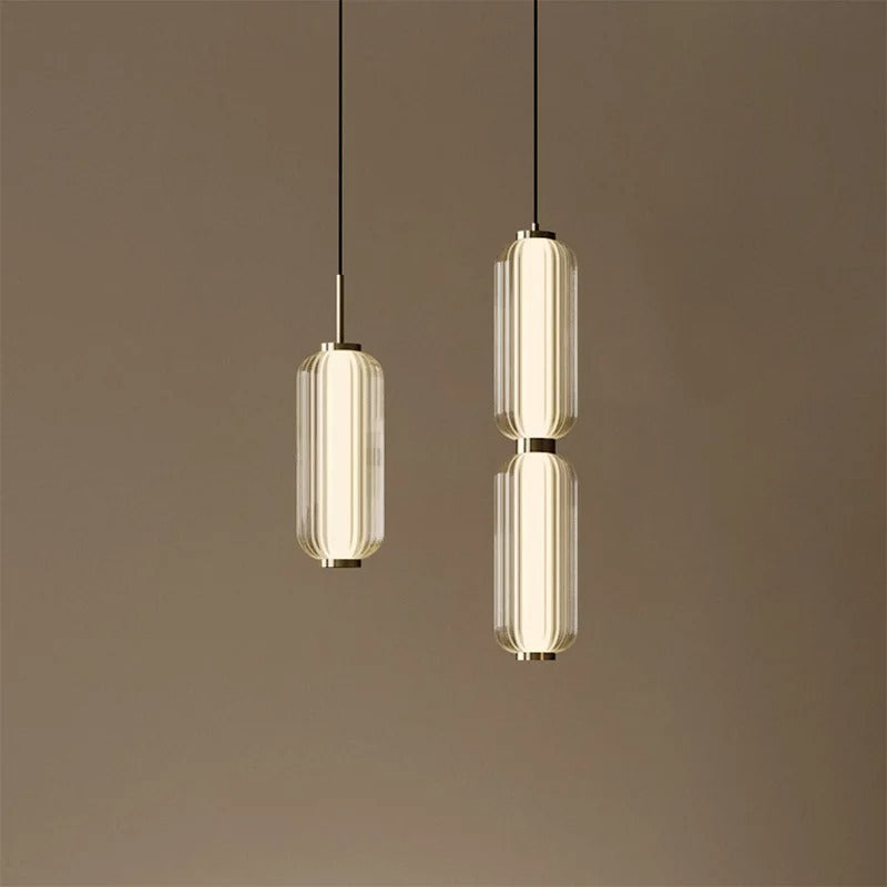 Two modern pendant lights hanging against a brown background