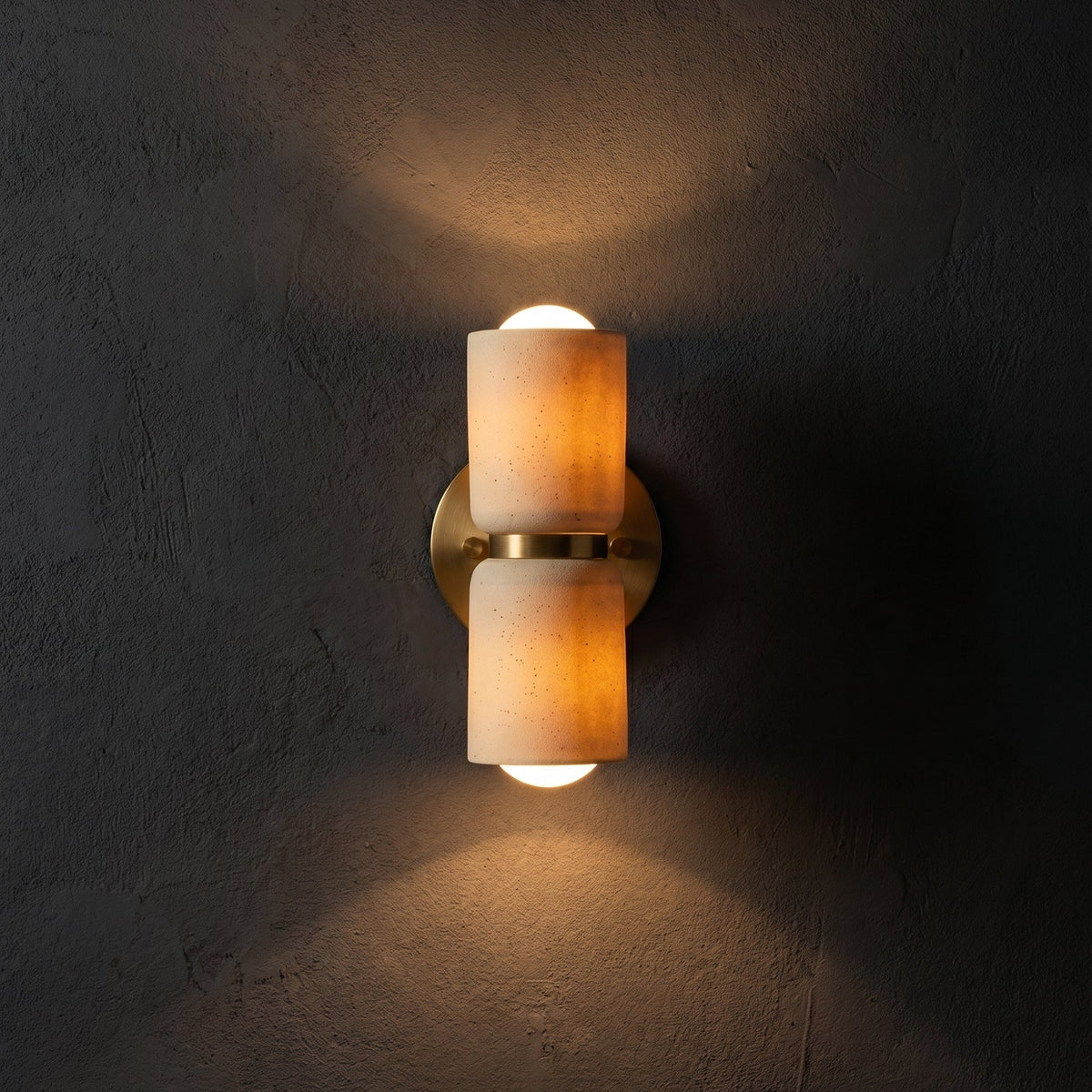 AX163 ceramic up down wall light glowing amber on a black wall, wabi sabi wall sconce