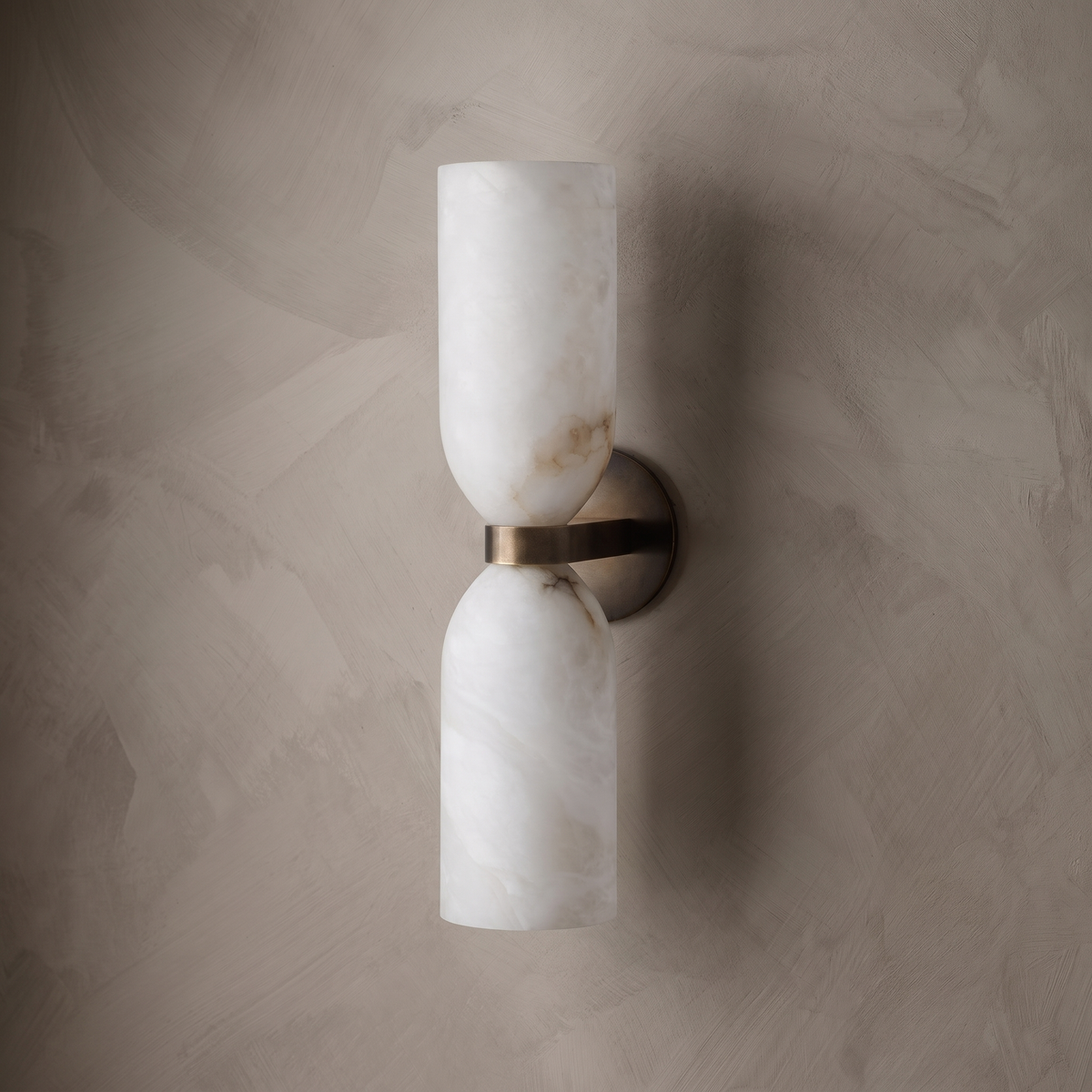 Tall alabaster bathroom wall sconce on a limewash plaster wall