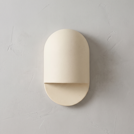 AX472 white outdoor wall light, front view of the arched ceramic sconce on a plaster wall