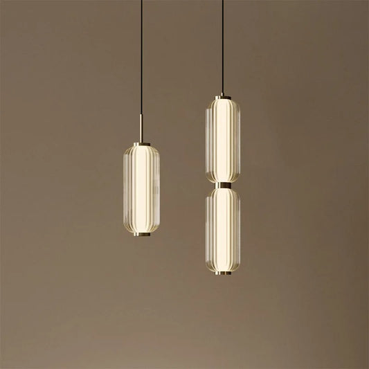 Two modern pendant lights hanging against a brown background