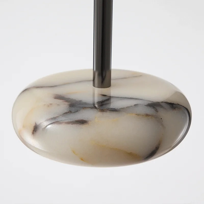 Marble-patterned object with a central rod on a light gray background